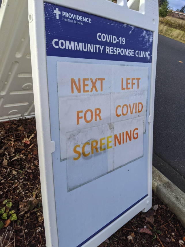 The main sign on the curb welcoming people for COVID screening