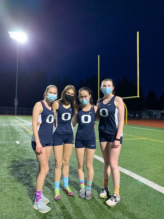 Sarah Swanstrom, Allison Holder, Isabella Widrow, and Hollen Foster-Grahler pose for a picture as OHS Cross Country teammates.