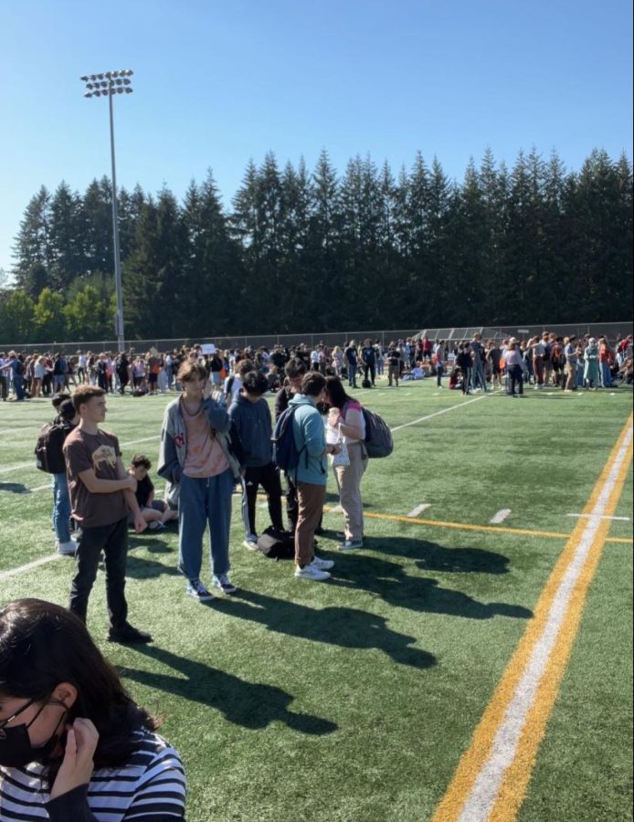 Students gather on the field during the second fire alarm.