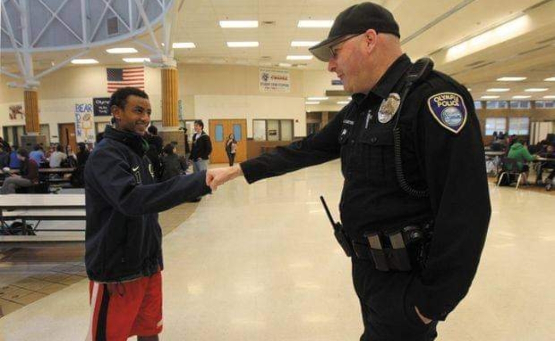 Former School Resource Officer Doug Curtright shakes hands with an OHS student. Photo courtesy of "Keep a School Resource Officer at OHS" on Facebook.