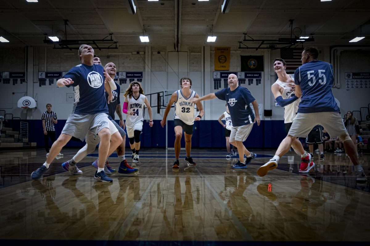 Players entangled in the game as they  fight for a position under the hoop.
