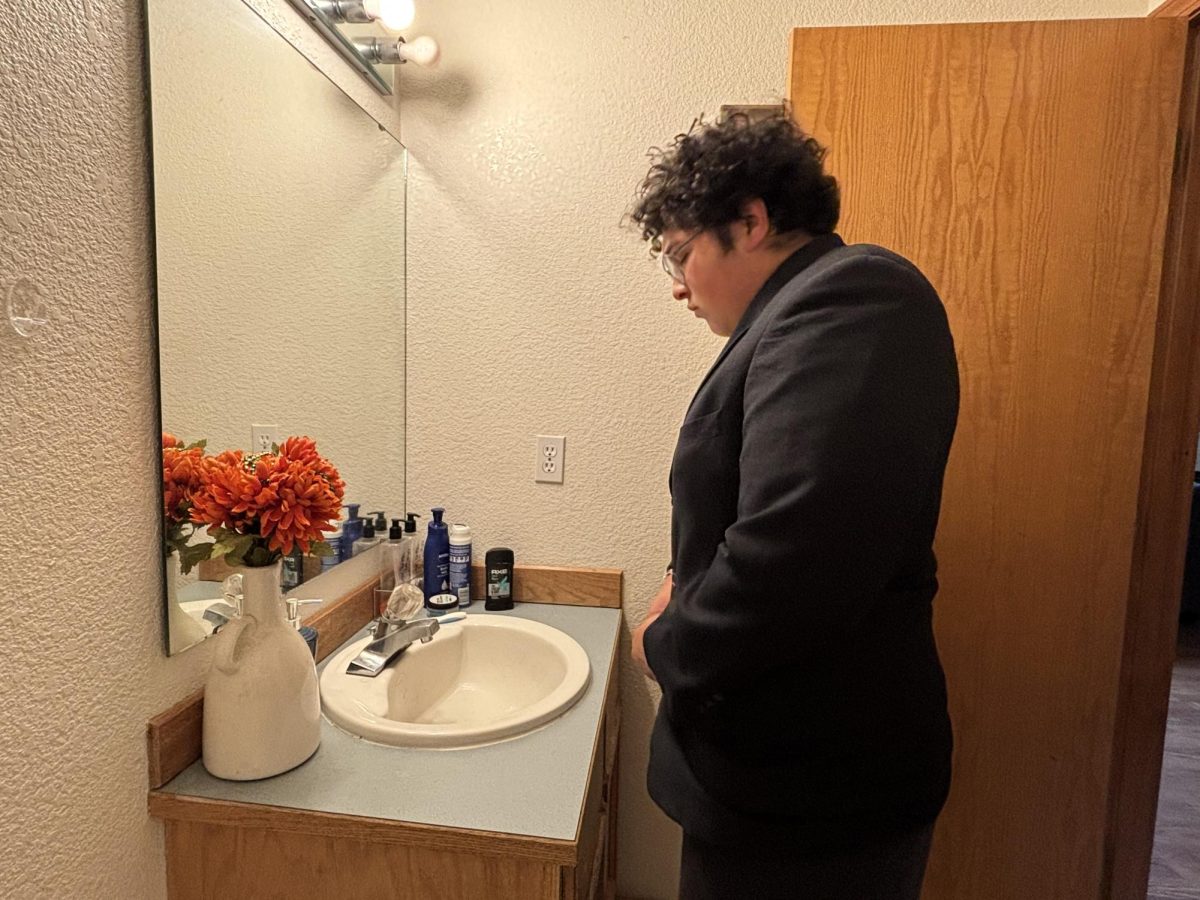Edmar Hernandez putting his tux on and getting ready to go pick up his date for prom so that they can have a great night.