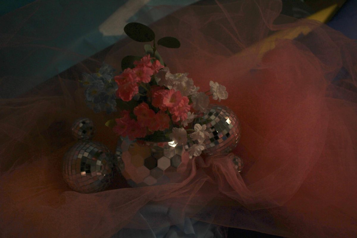 The decorations for "Promma Mia" feature fun disco balls with flowers as table centerpieces.